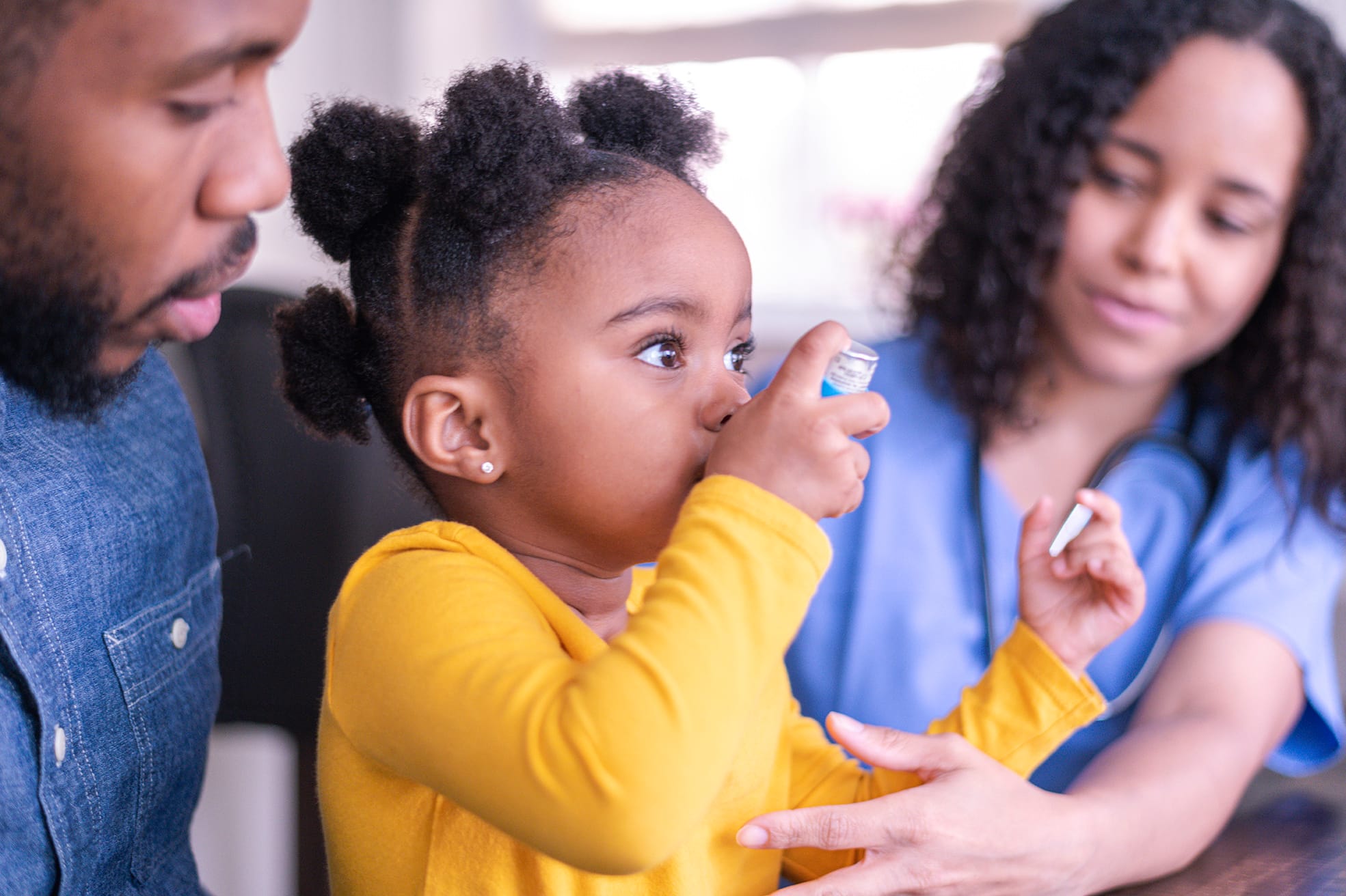 Girl at doctor’s appointment using an asthma inhaler